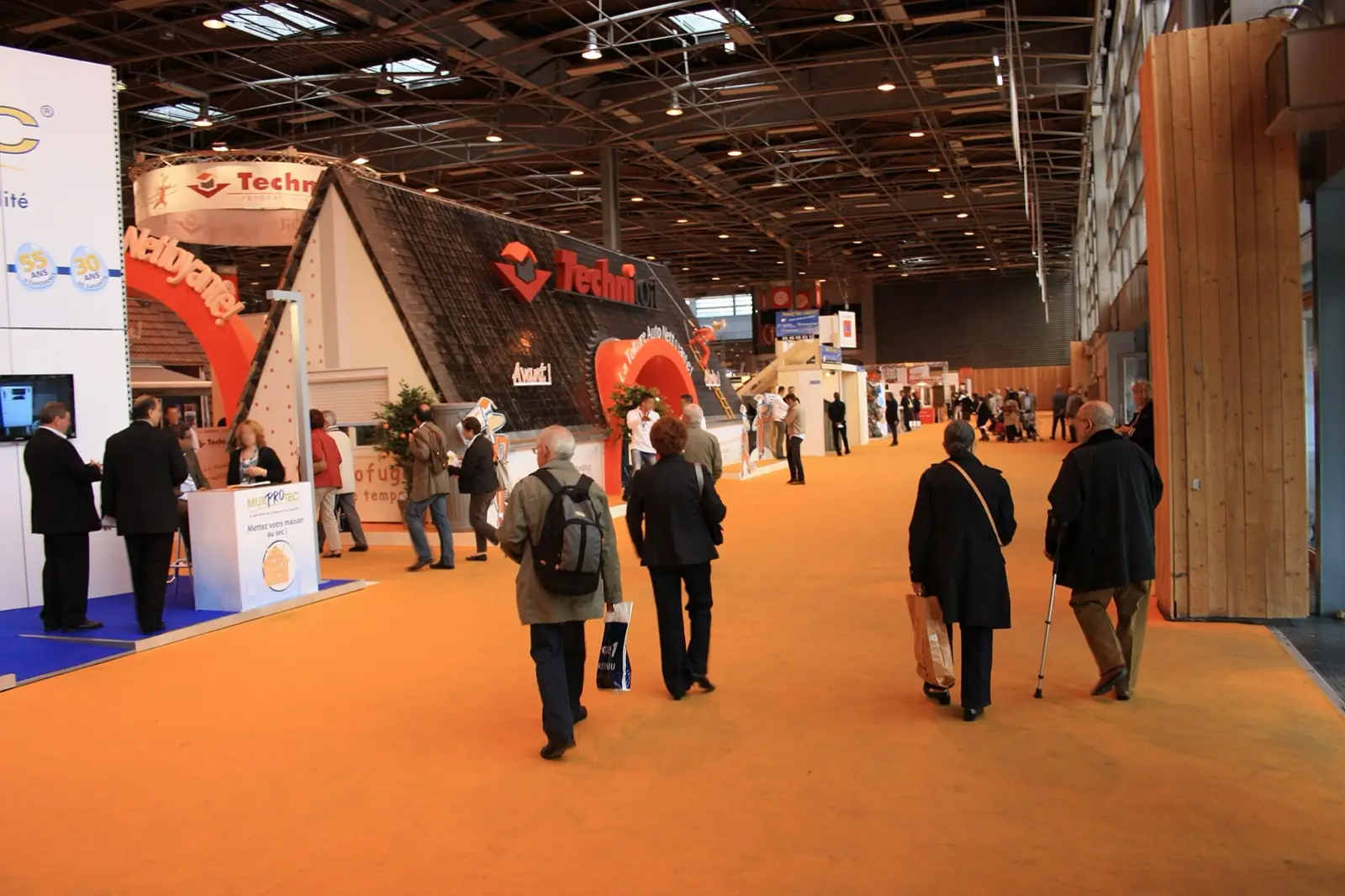 Allée d'une grande foire, stands et visiteurs